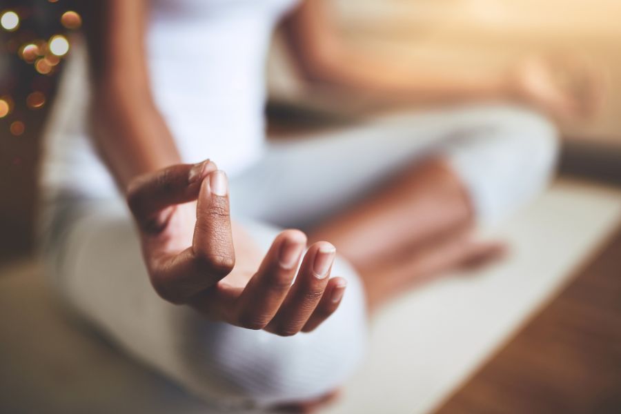una noia col·loca les mans en posició per fer ioga